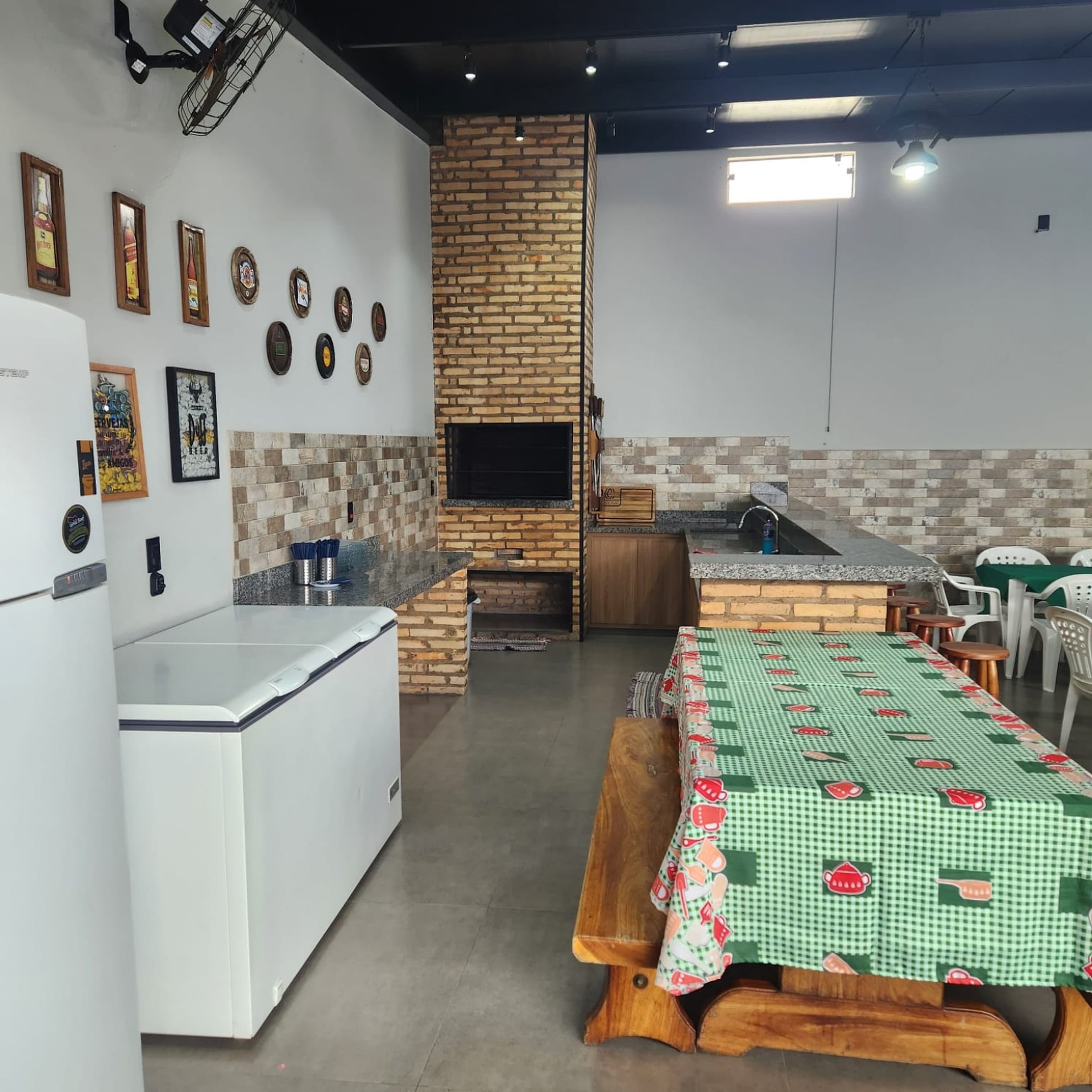 Churrasqueira de tijolo, bancada com pia, freezer e geladeira